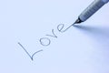 Fountain pen writing on a clean sheet of paper the word Love close up Royalty Free Stock Photo