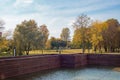 A fountain, a pond  surrounded by a brown wall, a green-yellow autumn park Royalty Free Stock Photo