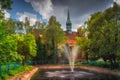 Fountain in pond surrounded by green trees and Church of Sts. Peter and Paul in Szczecin Royalty Free Stock Photo