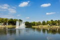 Fountain with rainbow in the artificial pond. Royalty Free Stock Photo
