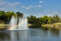 Fountain with rainbow in the artificial pond. Royalty Free Stock Photo