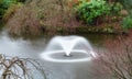 A fountain sprays water into a large pool in a park in England