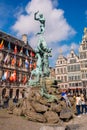 Fountain statue of Brabo throwing the severed hand of Antigoon into the Scheldt river with belfry of the Cathedral of our Lady,