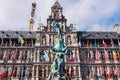 Fountain statue of Brabo throwing the severed hand of Antigoon into the Scheldt river with belfry of the Cathedral of our Lady,