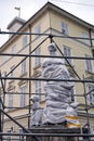 Fountain with a Statue of Diana on Rynok Square protected by metal construction and wrapping to avoid destruction and