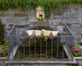 Fountain surrounded by metal fence and flanked by flower beds in Camogli, Italy Royalty Free Stock Photo