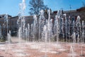 Fountain in the town square. A stream of water, drops and bright splashes in the fountain. A wonderful sunny day. Royalty Free Stock Photo