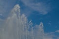 Fountain water jets on a background of blue summer sky close-up. Royalty Free Stock Photo