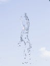 Fountain water splash against blurred sky with clouds, selective focus, shallow DOF Royalty Free Stock Photo