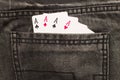 Four ace cards inside gray jeans back pocket