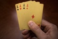 Four aces in hand, golden card in hands, four playing cards in the right hand Royalty Free Stock Photo