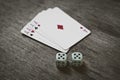 Four aces playing cards and two dice number double five on a wooden background. risk, luck, abstraction. Royalty Free Stock Photo