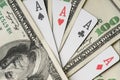 Four aces poker playing cards among U.S. dollars