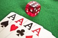 Four aces and red dice on green background Royalty Free Stock Photo