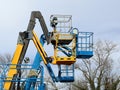 Four aerial working platforms of cherry picker. Overcast sky.