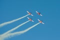 Four aerobatic planes perform maneuvers with smoke trails in blue sky Royalty Free Stock Photo