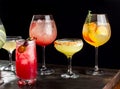 Four alcoholic cocktails with orange slices, ice, watermelon slices, cherries, pears and cucumbers.