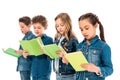 Four amazed children in denim clothes reading books isolated on white.
