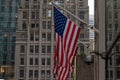 Four American Flags Waving On Flagpoles Protruding From Side of Building in New York City