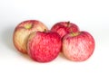 Four apples on white background. Red juicy ripe apples close up. Fresh striped fruit. Side view Royalty Free Stock Photo