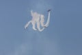 Four army jets flying up in the blue sky and performing a show leaving smoke marks