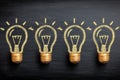Creative light bulb illustrations on a blackboard background representing ideas and inspiration Royalty Free Stock Photo