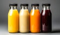 Four assorted fresh fruit juices in glass bottles with black caps on a neutral background, representing healthy dietary Royalty Free Stock Photo