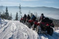 Four ATV riders on off-road quad bikes in the winter mountains Royalty Free Stock Photo