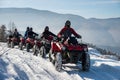 Four ATV riders on off-road four-wheelers ATV bikes in the winter mountains Royalty Free Stock Photo