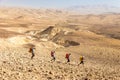 Four backpackers hiking trail, Negev desert, Israel.