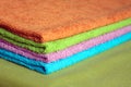 Four bath towels of different colors stacked closeup