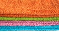 Four bath towels of different colors stacked isolated