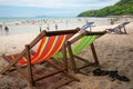 Four beach armchair with leather slippers with tourists on sandy beach Royalty Free Stock Photo