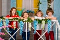 Four beautiful children, two boys and two girls stand on a wooden threshold and laugh Royalty Free Stock Photo