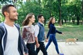 Four beautiful friends walking in park holding hands