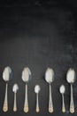 Four beautiful large silver spoons and three small spoons for desserts on a black background Royalty Free Stock Photo