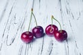 Four beautiful red cherries on a white wooden table