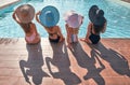 Four beautiful young woman sitting by the poolside of swimming pool during summer holiday Royalty Free Stock Photo