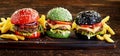 Four beef burgers on colorful buns