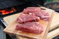 Fresh raw beef steaks on a wooden cutting board