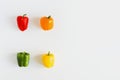 Four bell peppers of red, orange, green and yellow color on white background Royalty Free Stock Photo