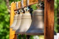 Four bells hang on a wooden frame on the street