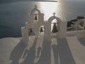 Four bells and shadows at sunset in oia, santorini