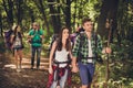 Four best friends are walking in autumn forest, amazed by the beauty of nature, wearing comfortable outfits for hiking, sneakers,