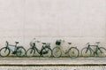 Four bicycles stand near a white brick wall