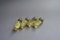 Four oblong yellow fish oil capsules