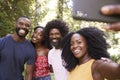 Four black adult friends take a selfie during a forest hike