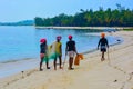 Four african black women on an amazing tropical beach holding fishing nets ready for a day of hard work in the ocean