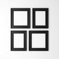 Four blank black photo frames on wall