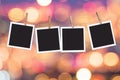 Four blank instant photo frames hanging on a rope on holiday lights bokeh background Royalty Free Stock Photo